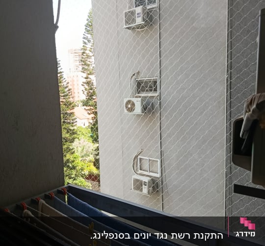 רשת הגנה על מרפסת עם מזגנים ברקע